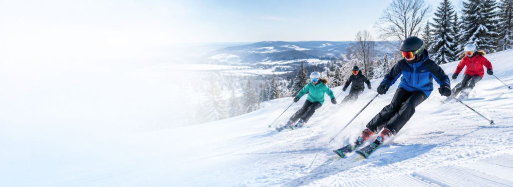 4 teenage skiers going downhill doing skills and drills